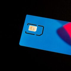 A blue sim card sits on a dark surface.